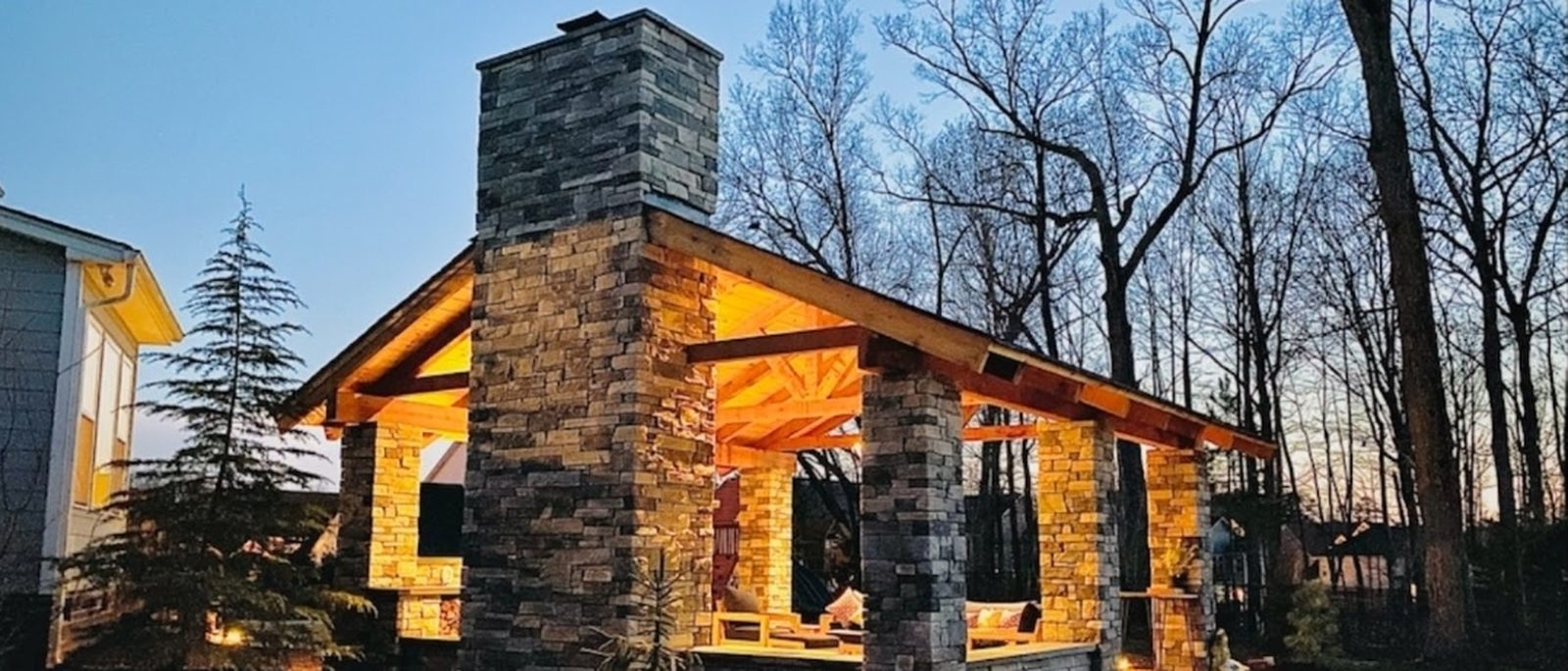 A stone-and-timber pavilion lit at twilight