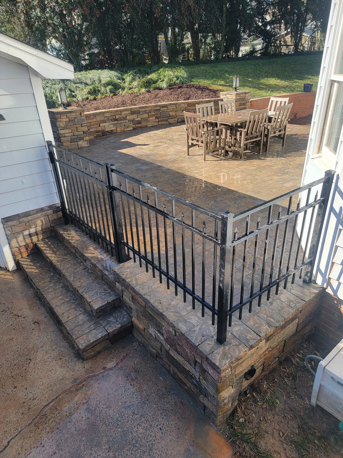 Elevated paver patio with steps and railing at the Matthews Mill House project