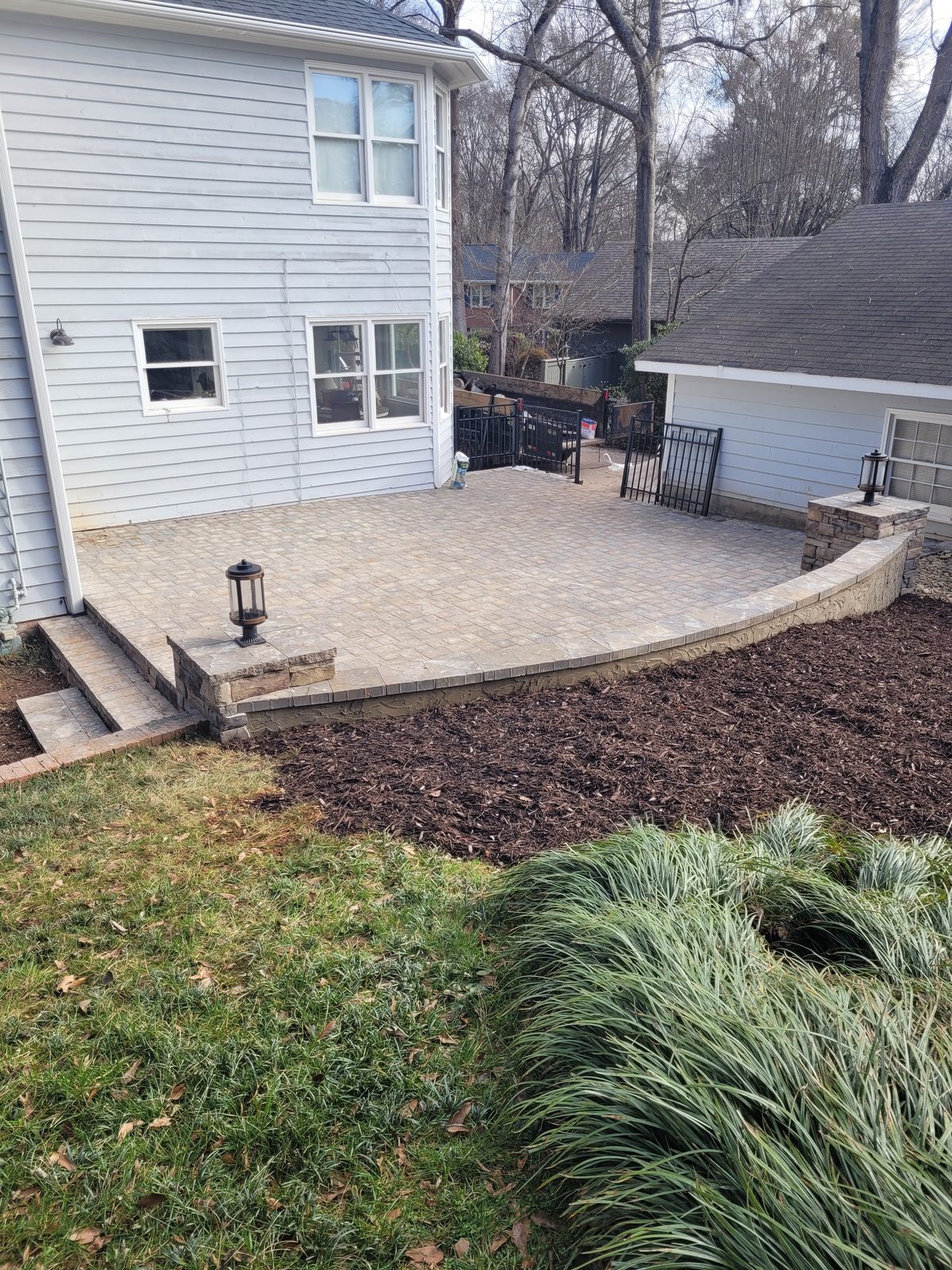 Paver patio integrated with existing landscaping at the Matthews Mill House project