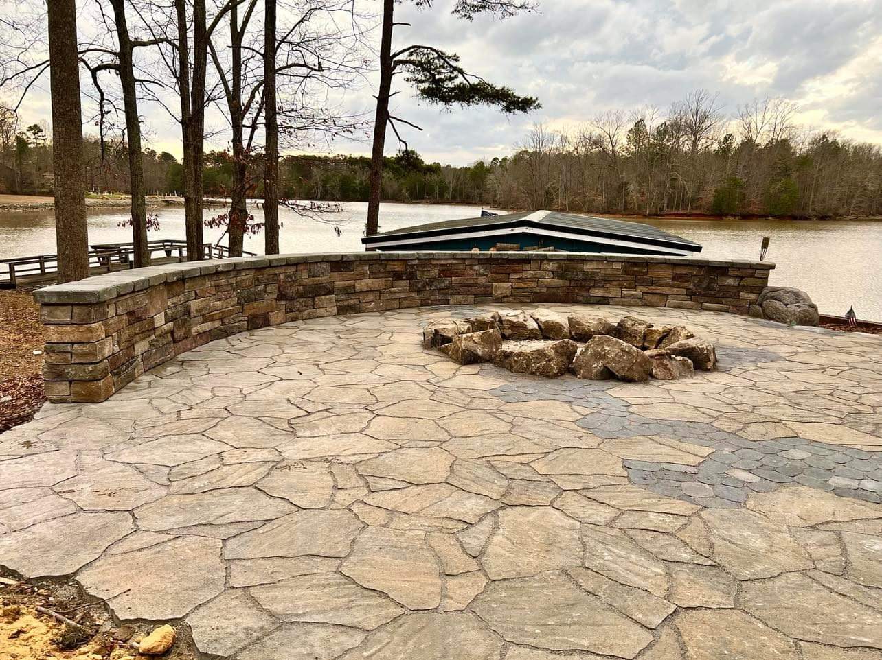 Lakeside flagstone patio and fire pit with stacked-stone seat wall at Lake Tillery